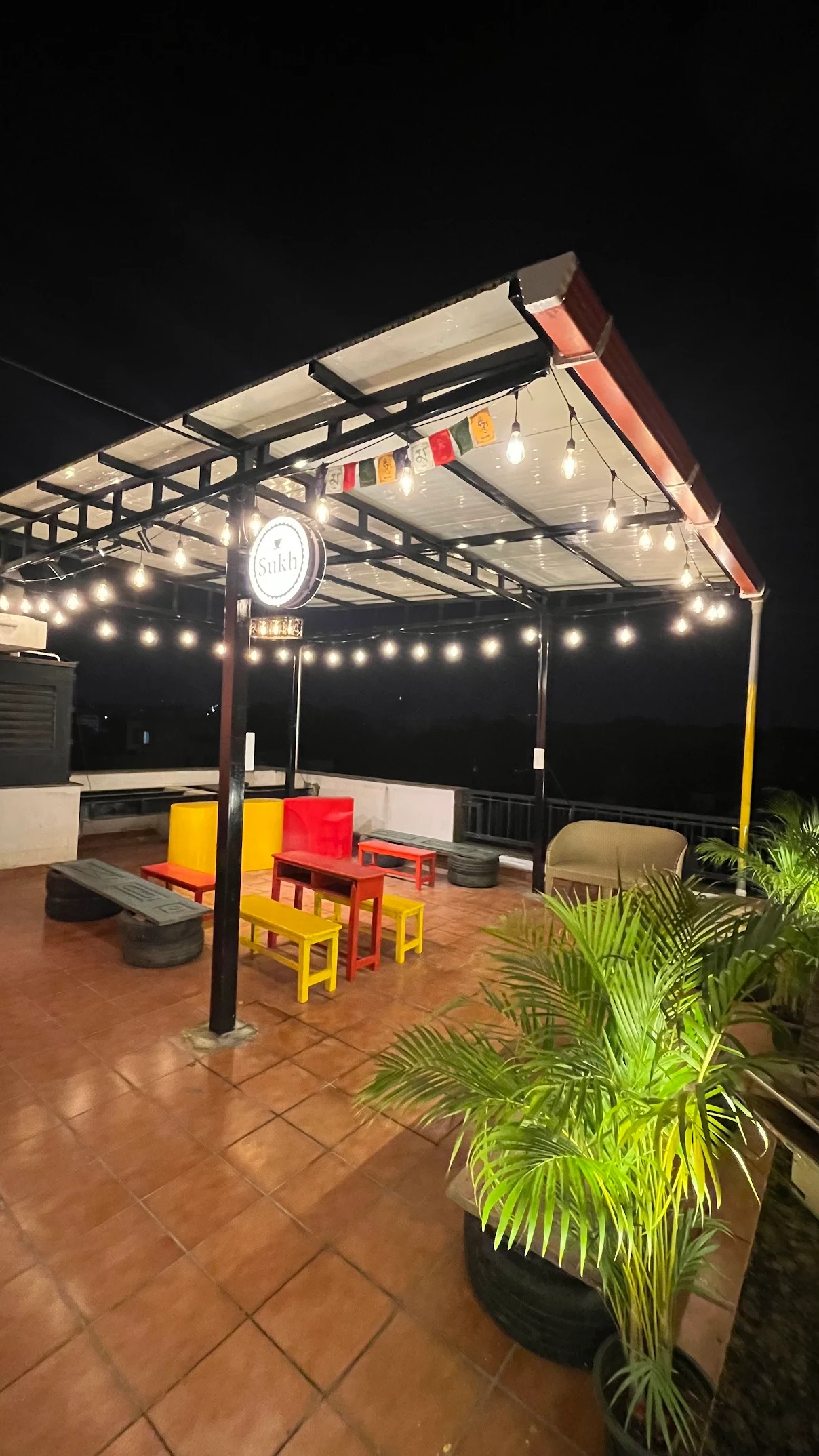 A Nia Studio rooftop lounge under string lights at night